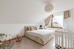 a bedroom with a bed and a crib and a window at Luxury Apartment Marz in Schwanau