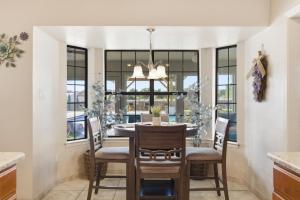 a dining room with a table and chairs and a chandelier at Private Beach Volleyball Pool Retreat in Las Cruces