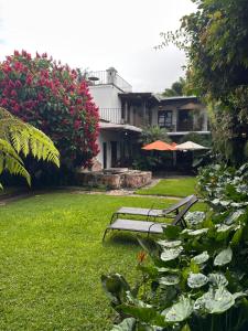two park benches sitting in the grass in front of a house at Villa de Antaño in Antigua Guatemala +30 photos