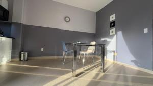a dining room with two chairs and a glass table at RC Apartments Suriname in Paramaribo