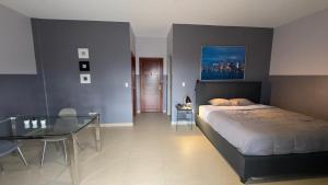 a bedroom with a bed and a glass table at RC Apartments Suriname in Paramaribo