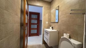 a bathroom with a toilet and a sink and a mirror at RC Apartments Suriname in Paramaribo +14 photos