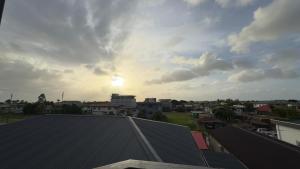 a view from a roof of a city with the sun setting at RC Apartments Suriname in Paramaribo
