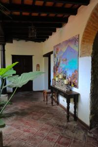 a room with a table and a painting on the wall at Villa de Antaño in Antigua Guatemala