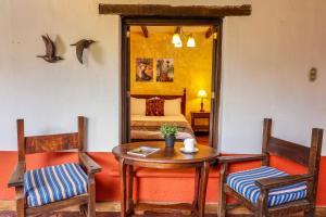 a room with a table and two chairs and a bed at Villa de Antaño in Antigua Guatemala