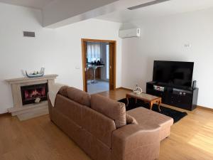 a living room with a couch and a fireplace at Casa da Tininha in Alcobaça