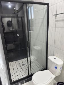 a bathroom with a shower with a toilet and a glass door at Tu refugio en el corazon de David in David
