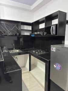 a black and white kitchen with a sink and a microwave at Tu refugio en el corazon de David in David