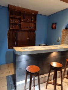 a kitchen with a counter and two stools at Casa Maya Vibes in Santiago Atitlán