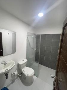 a bathroom with a toilet and a shower and a sink at AMAREA Hotel Boutique in Tolú