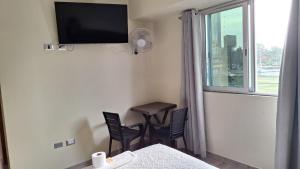 a room with a bed and a table and a window at Hostal Plaza Grau in Lima