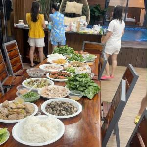 a table with many plates of food on it at Osaka Villa Phan Thiet in Ấp Bình Hưng