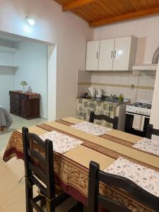 a kitchen with a table with chairs and a stove at Departamento Salomé in Eduardo Castex