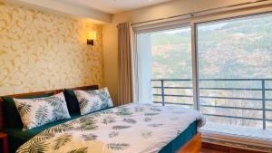 a bedroom with a bed and a large window at Murree Spring Apartment in Murree