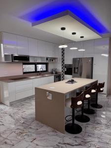 a kitchen with a large island with bar stools at N3XT LEVEL home in Praia