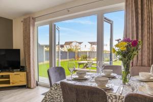 a dining room with a table and a large window at 3 Bed in Brynteg oc-d33659 in Brynteg