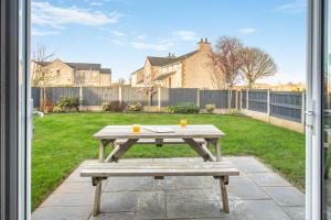 a picnic table with two cups on it in a yard at 3 Bed in Brynteg oc-d33659 in Brynteg
