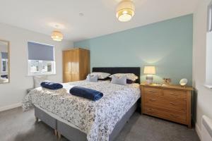 a bedroom with a bed with blue pillows on it at 3 Bed in Brynteg oc-d33659 in Brynteg