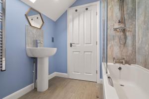 a bathroom with a sink and a tub and a shower at 3 Bed in Brynteg oc-d33659 in Brynteg +14 photos