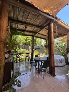 a patio with a table and chairs and a bed at Bambuk Bio Dome Uvita beach front in Uvita