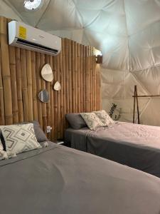 a bedroom with two beds in a tent at Bambuk Bio Dome Uvita beach front in Uvita