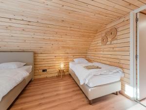 two beds in a room with wooden walls at ZweveZalig in Zwevezele