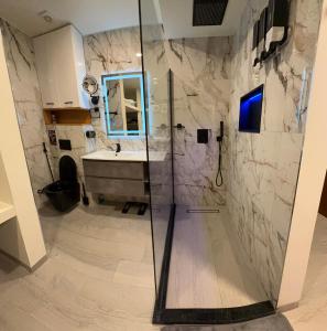 a bathroom with a sink and a glass shower at N3XT LEVEL home in Praia