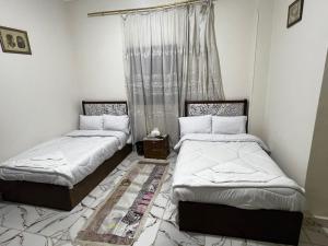 two beds in a room with a window at tulip pyramids iin in Nazlet el-Sîsi +9 photos