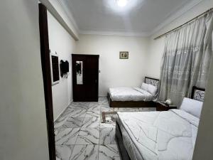 a room with two beds and a window and a room with two beds at tulip pyramids iin in Nazlet el-Sîsi