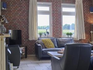 a living room with a couch and a brick wall at t Achterhoes in Neede