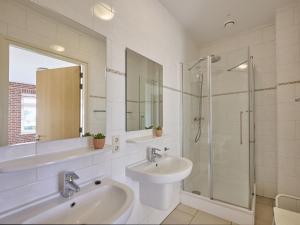 a bathroom with two sinks and a glass shower at t Achterhoes in Neede +41 photos