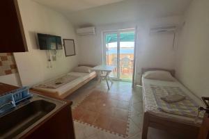 a kitchen with two beds and a sink in it at Apartments by the sea Povljana, Pag - 3316 in Povljana