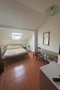 a bedroom with a bed and a table and a desk at Apartments by the sea Povljana, Pag - 3316 in Povljana