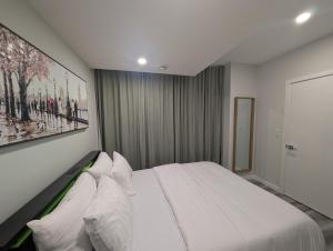 a bedroom with a large bed with white pillows at Calgary Serene Suite - 19mins from airport, 1hr to Banff, 85" Cinema, Fibre WiFi, Full Kitchen in Calgary
