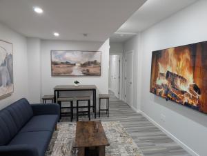 a living room with a couch and a table at Calgary Serene Suite - 19mins from airport, 1hr to Banff, 85" Cinema, Fibre WiFi, Full Kitchen in Calgary