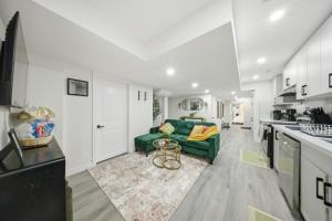 a living room with a green couch and a kitchen at Caledon Quiet Luxury Escape 3BR Suite in Brampton