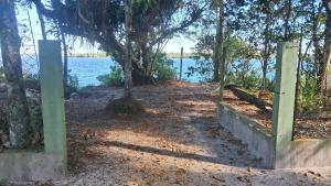 a gate to a path next to a body of water at Cananéia Apoio Tours in Cananéia +4 photos
