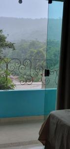 a room with a large glass window with a view at Hospedaria Mandassaia in Lençóis