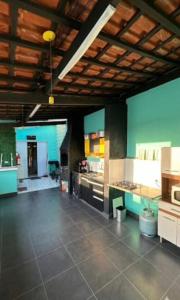 a large room with a kitchen with blue walls at Moriah Hostel e Pousada in Praia Grande