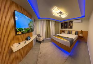a bedroom with a bed and a tv on a wall at N3XT LEVEL home in Praia