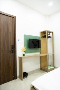 a room with a tv and a shelf with a television at Đầm Nại Hotel in Ninh Hải