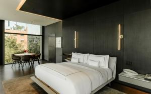 a bedroom with a large white bed and a table at Alexander, Member of The Leading Hotels of the World in Mexico City