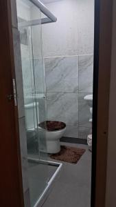 a bathroom with a glass shower and a toilet at Cananéia Apoio Tours in Cananéia