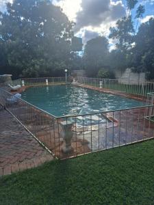 a swimming pool with a fence around it at Eastview Guest House in Harare
