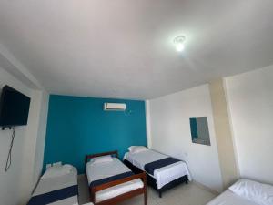a room with two beds and a blue wall at AMAREA Hotel Boutique in Tolú