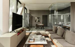 a living room with a couch and a tv at Alexander, Member of The Leading Hotels of the World in Mexico City