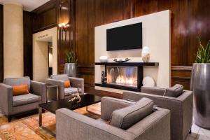 a living room with a fireplace and a tv at The Whitehall Houston in Houston