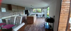 a kitchen and a living room with a glass table at Finca y Chalet MA in Chiquinquirá