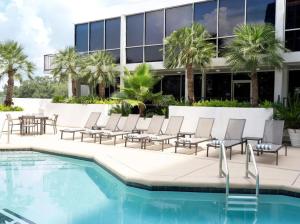 a pool with chairs next to a building at The Whitehall Houston in Houston