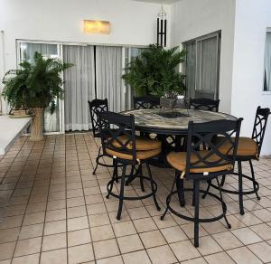 a black table and chairs in a living room at Beautiful house with a pool in Mérida